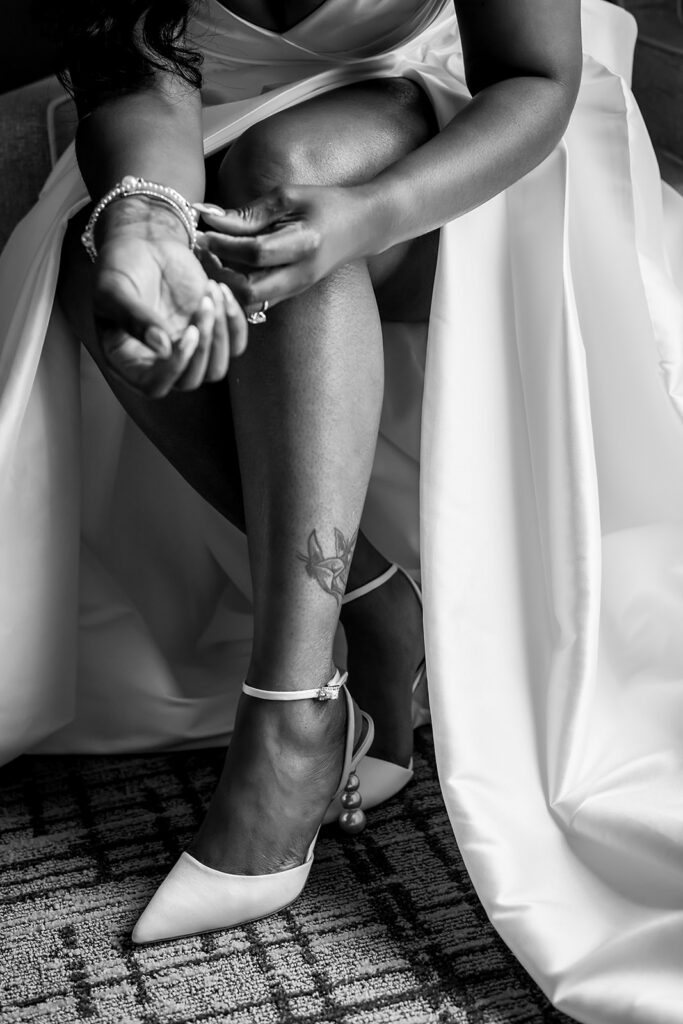 Elopement at Chateau Elan Winery captured by JAM&CO Studios Atlanta Elopement photographer Black and white photo of bride putting on jewelry and shoes
