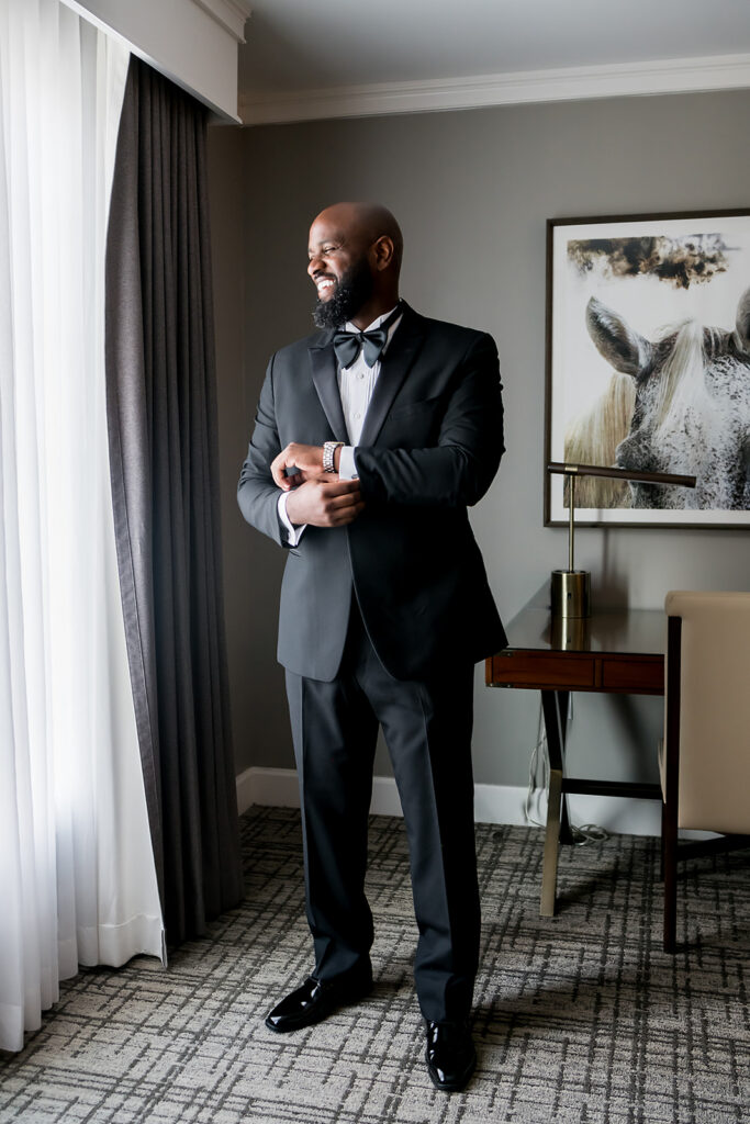 Elopement at Chateau Elan Winery captured by JAM&CO Studios Atlanta Elopement photographer photo of groom laughing and looking out window