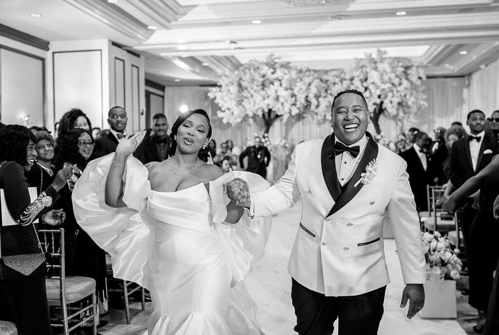 The Whitley Hotel Wedding captured by JAM&CO Studios wedding photo and video team black and white photo of bride and groom going exiting the ceremony